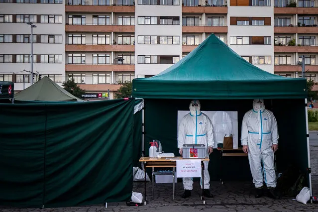 Election committee members wearing a protective suits, wait for voters at a drive-in polling station during regional and senate elections on September 30, 2020 in Prague, Czech Republic. For the country's upcoming regional and senate elections, authorities have created drive-in polling stations for voters required to quarantine amid the Covid-19 pandemic. After initial success in curbing an outbreak, the Czech Republic has seen a surge of Covid-19 cases in recent weeks. (Photo by Gabriel Kuchta/Getty Images)