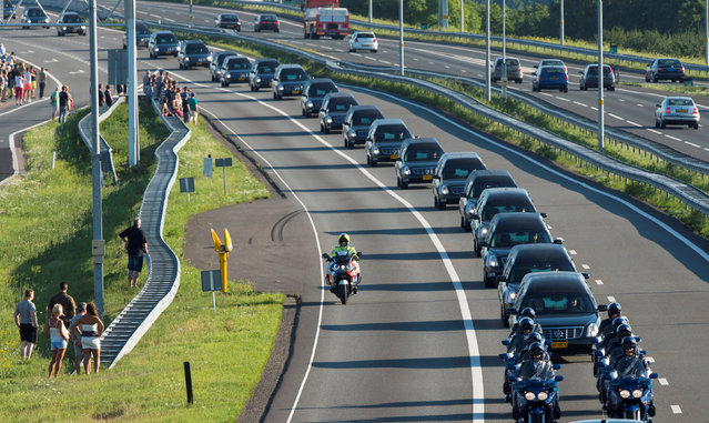 A row of hearses carrying victims of the Malaysia Airlines flight MH17 plane disaster are escorted on highway A27 near Nieuwegein by military police, on their way to be identified by forensic experts in Hilversum, July 23, 2014. (Photo by Marco de Swart/Reuters)