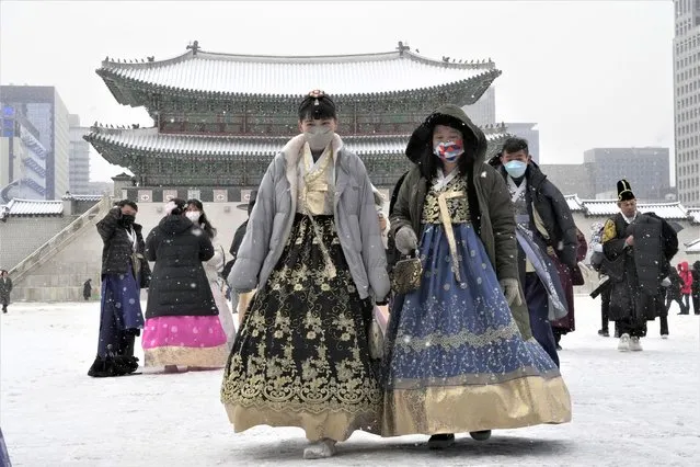 Women wearing traditional “Hanbok” outfits walk in the snow at the Gyeongbok Palace, the main royal palace during the Joseon Dynasty, and one of South Korea's well known landmarks in Seoul, South Korea, Thursday, anuary 26, 2023. (Photo by Ahn Young-joon/AP Photo)