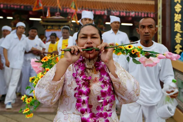 A devotee of the Chinese Ban Tha Rue shrine with piercings of stems at her face takes part in a procession celebrating the annual vegetarian festival in Phuket, Thailand, October 5, 2016. (Photo by Jorge Silva/Reuters)