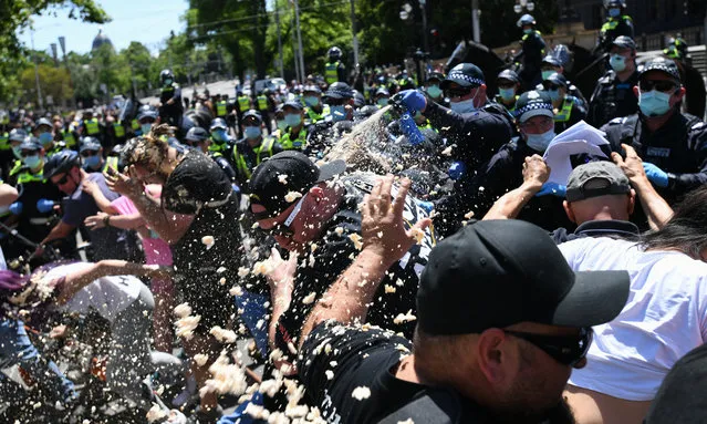 Police use OC spray on protesters during an anti-lockdown protest in Melbourne, Tuesday, November 3, 2020. Anti-lockdown protesters have hit the streets outside the Victorian parliament despite COVID-19 restrictions drastically easing in Melbourne last week. (Photo by Erik Anderson/AAP Image)