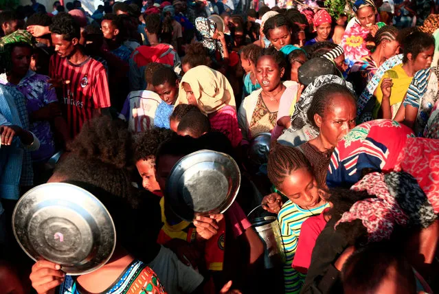 Ethiopian migrants who fled intense fighting in their homeland of Tigray, wait for their ration of food in the border reception center of Hamdiyet, in the eastern Sudanese state of Kasala, on November 14, 2020. Ethiopia's Prime Minister Abiy Ahmed, winner of last year's Nobel Peace Prize, ordered military operations in Tigray last week, shocking the international community which fears the start of a long and bloody civil war. (Photo by Ebrahim Hamid/AFP Photo)