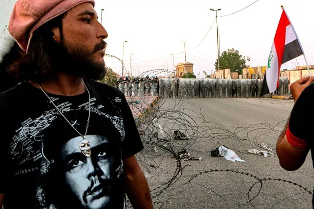 A protester wears a T-shirt with an image of Cuba's revolutionary hero Ernesto “Che” Guevara while security forces try to disperse anti-government protesters during ongoing protests in Basra, Iraq, Friday, November 13, 2020. (Photo by Nabil al-Jurani/AP Photo)