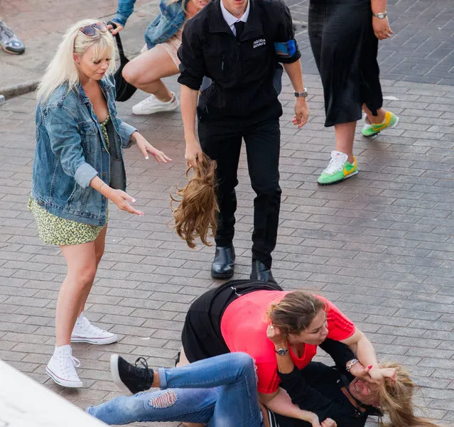 Picture show the two women break out into a full-on fight before a security worker steps in on the seafront in Brighton, Sussex, UK on August 2, 2020. (Photo by London News Pictures)
