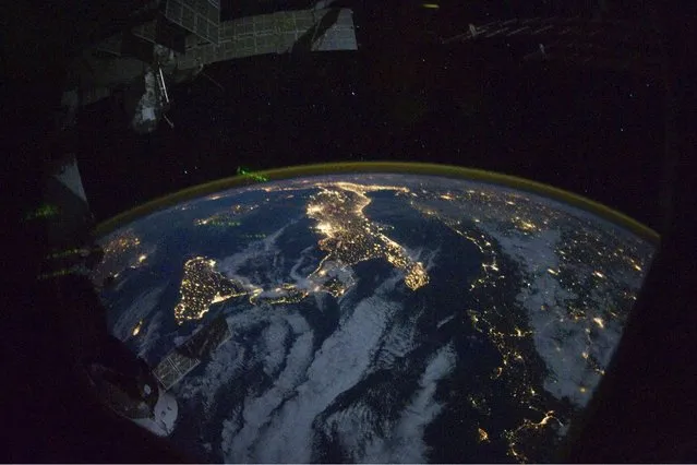 This image provided by NASA shows parts of Europe and Africa very easily recognizable in this night time image shot by one of the Expedition 25 crew members aboard the International Space Station flying 220 miles above Earth on Thursday Oct. 28, 2010. The view “looks” northward over Sicily and the “boot” of Italy, with the Mediterranean Sea representing most of the visible water in the view and the Adriatic Sea to the right of center. Tunisia is partially visible at left. Part of a docked Russian spacecraft and other components of the ISS are in the foreground. (Photo by AP photo/NASA)
