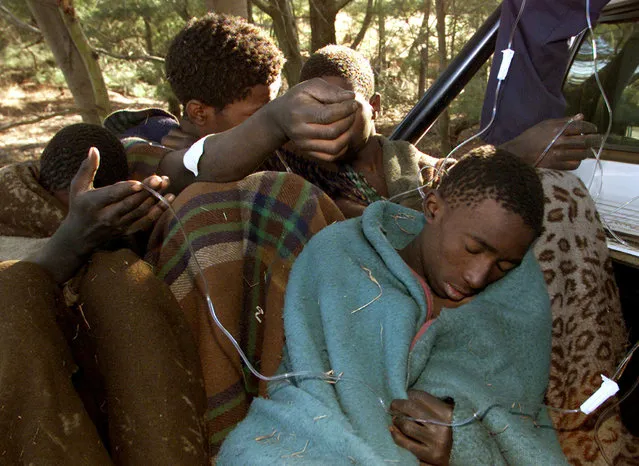 Young South African boys, survivors of a traditional initiation ceremony receive medical care before being transported to hospital June 25, 2002. (Photo by Juda Ngwenya/Reuters)