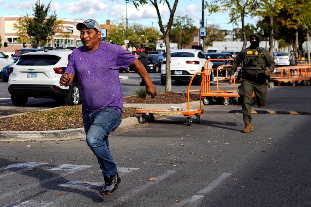 A federal agent chases a man in the parking lot of a Home Depot in Chicago, on October 11, 2025. (Photo by Jim Vondruska/Reuters)
