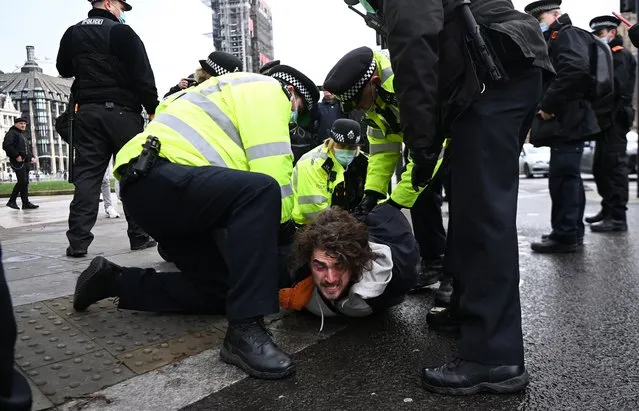 A man is arrested by police during an anti lockdown protest at Parliament Square in London, Britain, 06 January 2021. Police made a number of arrests during anti-lockdown protests at parliament square in London. (Photo by Andy Rain/EPA/EFE)