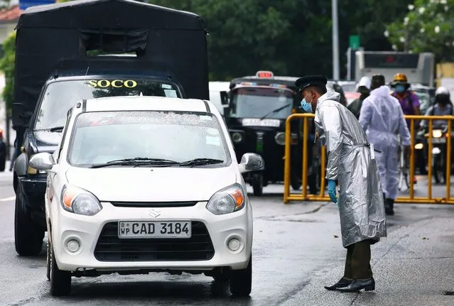 A police officer checks vehicles in a locked-down area due to a surge of COVID-19 cases in Colombo, Sri Lanka, November 16, 2020. (Photo by Ajith Perera/Xinhua News Agency)