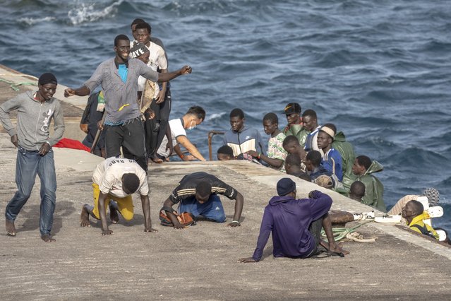 Migrants react as they arrive at the port in La Restinga on the Canary island of El Hierro, Spain, Monday, August 19, 2024. Emergency services on Spain's Canary Islands say 86 migrants have arrived in a boat on the Canary Island of El Hierro on Monday, after a seven-day sailing from the coast of Senegal. (Photo by Maria Ximena/AP Photo)