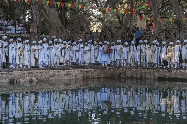 Ethiopian Orthodox Christian priests sing next to the pool of Fasilides Bath during the celebration of Timkat, the Ethiopian Epiphany, in the city of Gondar, Ethiopia, on January 19, 2021. Timkat is the Ethiopian Orthodox Christian festival which celebrates the baptism of Jesus in the Jordan river. The celebration has been recently declared Intangible Human Heritage by UNESCO. (Photo by Eduardo Soteras/AFP Photo)