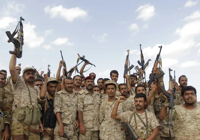 Military men wave their weapons at an army post at al-Mahfad, in the southern Yemeni province of Abyan May 23, 2014. (Photo by Khaled Abdullah/Reuters)