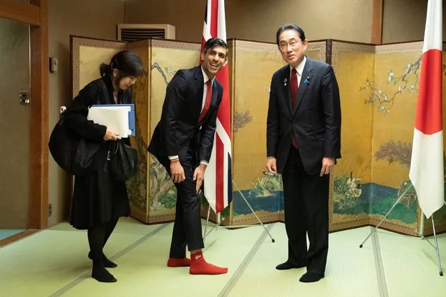 Prime Minister Rishi Sunak shows off his socks to  Japanese Prime Minister Fumio Kishida, which has the name of Kishida's favorite baseball team, Hiroshima Toyo Carp, on them, during their bilateral meeting in Hiroshima ahead of the G7 Summit, on May 18, 2023 in Hiroshima, Japan. (Photo Stefan Rousseau – WPA Pool/Getty Images)