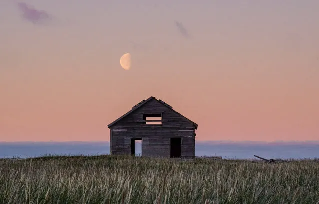 The moon rises on the old Mission House of Qikiqtaruk-Herschel, a remote island in the Canadian Arctic. The abandoned building is now home to a seabird colony. (Photo by Sandra Angers)