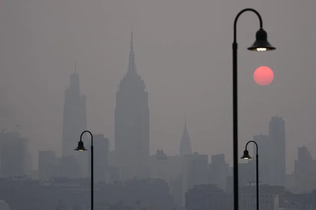 The sun rises over a hazy New York City skyline as seen from Jersey City, N.J., Wednesday, June 7, 2023. Intense Canadian wildfires are blanketing the northeastern U.S. in a dystopian haze, turning the air acrid, the sky yellowish gray and prompting warnings for vulnerable populations to stay inside. (Photo by Seth Wenig/AP Photo)