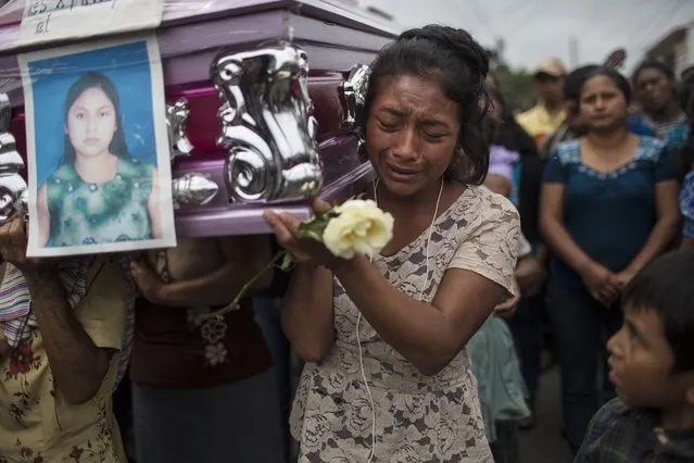 Yoselin Rancho cries while carrying the the remains of her best friend, Etelvina Charal, who died due to the eruption of the Volcan de Fuego, or Volcano of Fire, in San Juan Alotenango, Guatemala, Sunday, June 10, 2018. Risks from the Volcano of Fire are not over even though its activity has been decreasing, according to Guatemalan Seismology and vulcanology Institute Director Eddy Sanchez, saying the last time it erupted, it took two and a half weeks for the volcano to return to normal. (Photo by Rodrigo Abd/AP Photo)