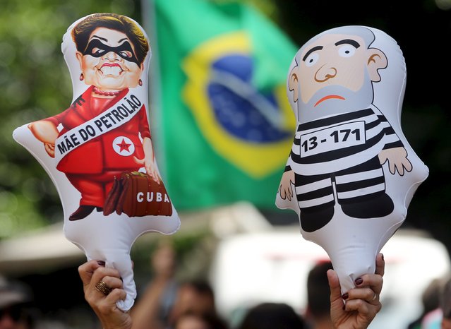 A demonstrator holds inflatable dolls depicting Brazil's President Dilma Rousseff (L) and Brazil's former president Luiz Inacio Lula da Silva as they take part in a protest calling for the impeachment of Rousseff at Paulista Avenue in Sao Paulo, Brazil, December 13, 2015. (Photo by Paulo Whitaker/Reuters)