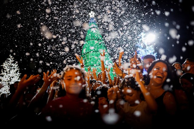 Children play with soap suds simulating snowfall during Christmas season celebrations at the Esplanade of Ministries in Brasilia, Brazil on December 11, 2024. (Photo by Adriano Machado/Reuters)