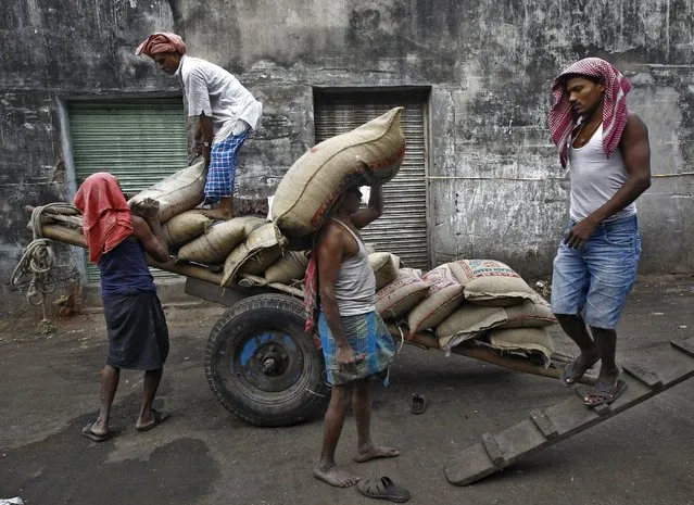 Labourers unload sacks of rice from a handcart at a wholesale market in Kolkata, India, December 14, 2015. (Photo by Rupak De Chowdhuri/Reuters)