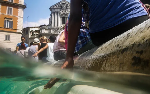 A tourist refreshes in the water of Rome's landmark Trevi fountain on July 24, 2013, as Italy is experiencing this week its first summer heatwave with temperatures reaching 40 degrees celsius. (Photo by Andreas Solaro/AFP Photo)