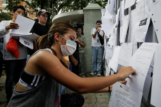 An opposition supporter sticks prescriptions to the gates of the Apostolic Nunciature building, during a protest against a shortage of medicines and to demand a referendum to remove President Nicolas Maduro in Caracas, Venezuela November 17, 2016. (Photo by Marco Bello/Reuters)