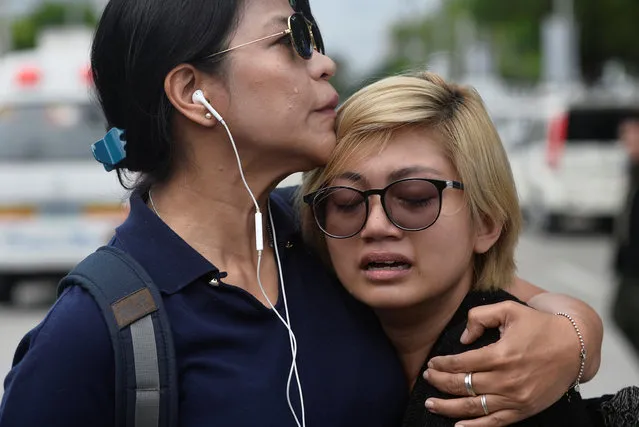 An anti-Marcos protester (R) breaks down in tears as another protester comforts her, outside the Libingan ng Mga Bayani (heroes' cemetery) where burial rites for former Philippine dictator Ferdinand Marcos took place, in Taguig city, Metro Manila, Philippines November 18, 2016. (Photo by Ezra Acayan/Reuters)