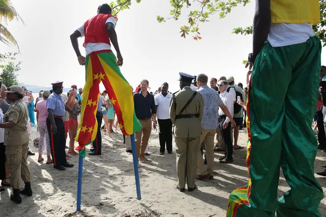 Britain's Prince Harry watches stilt walkers during an official visit to St.George's, Grenada November 28, 2016. (Photo by Carlo Allegri/Reuters)