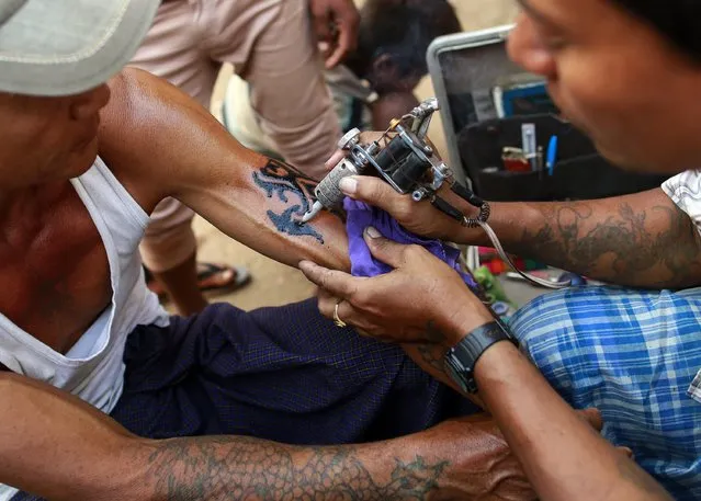 A man gets a tattoo at the Kyaik-Khauk pagoda festival in the Tanlyin township outside Yangon February 4, 2015. (Photo by Soe Zeya Tun/Reuters)