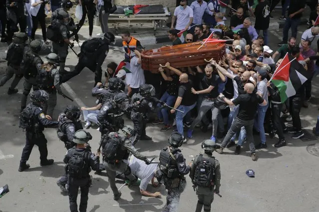 Israeli police confront with mourners as they carry the casket of slain Al Jazeera veteran journalist Shireen Abu Akleh during her funeral in east Jerusalem, Friday, May 13, 2022. Abu Akleh, a Palestinian-American reporter who covered the Mideast conflict for more than 25 years, was shot dead Wednesday during an Israeli military raid in the West Bank town of Jenin. (Photo by Maya Levin/AP Photo)