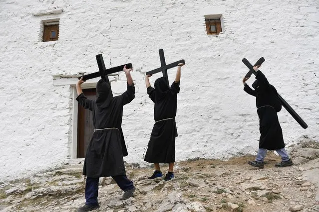 Penitents carry crosses during the “Romeria a la Trinidad” pilgrimage in the village of Lumbier on June 12, 2022. The pilgrimage of Lumbier is a penitential celebration that takes place every year on Sunday of the Holy Trinity (Photo by Ander Gillenea/AFP Photo)