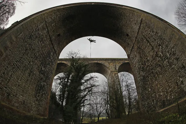 Rope access specialist Simon Ginn, of contractors Fountains, abseils down the Chirk aqueduct during vital maintenance work to remove unwanted vegetation which has taken root in crevices of the Grade II listed aqueduct on December 14, 2016 in Wrexham, Wales. The work is part of a wider Canal & River Trust project to protect heritage structures along the Llangollen and Montgomery canals. The Chirk aqueduct stands next to the rail viaduct and was built by famous canal engineer Thomas Telford between 1796 and 1801. Chirk Aqueduct is 70-foot (21 m) high and 710-foot (220 m) long and carries the Llangollen Canal across the Ceiriog Valley. (Photo by Christopher Furlong/Getty Images)