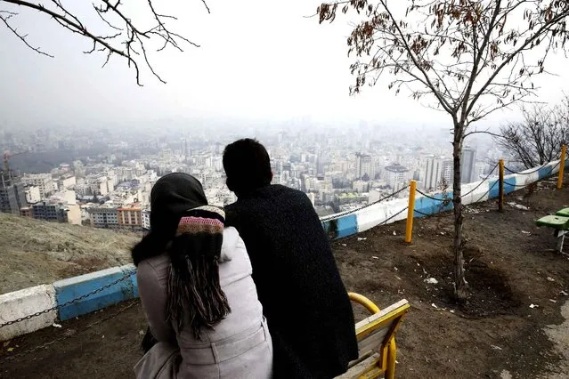 An Iranian man and woman look at the view from the Tochal mountainous area, in northern Tehran, Iran, Sunday, December 20, 2015. High air pollution has forced Iranian authorities to close all schools and kindergartens in the capital for two days beginning Sunday, saying the pollution had reached dangerous levels. (Photo by Vahid Salemi/AP Photo)