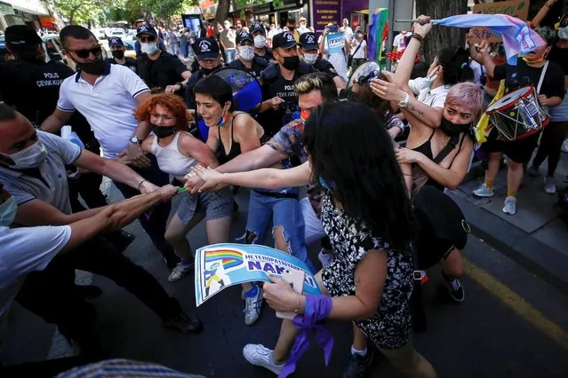Demonstrators scuffle with plain-clothes police officers as they try to gather for a Pride parade, which was banned by local authorities, in central Ankara, Turkey on June 29, 2021. (Photo by Cagla Gurdogan/Reuters)