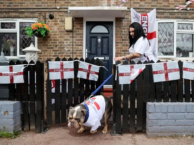 A woman with an England shirt on her and the dog in London before their match against Denmark on July 7, 2021. (Photo by Carl Recine/Reuters)