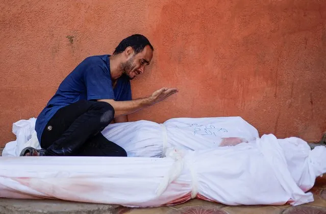 Palestinian man Mohammed al-Akhras reacts next to the bodies of his daughter Jana and his wife who were killed by Israeli strikes, in Khan Younis in the southern Gaza Strip on October 26, 2023. (Photo by Mohammed Salem/Reuters)