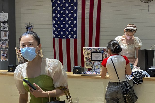 A woman wearing a face mask visits a fashion boutique in Beijing, Sunday, July 11, 2021. China on Sunday said it will take “necessary measures” to respond to the U.S. blacklisting of Chinese companies over their alleged role in abuses of Uyghur people and other Muslim ethnic minorities. (Photo by Andy Wong/AP Photo)