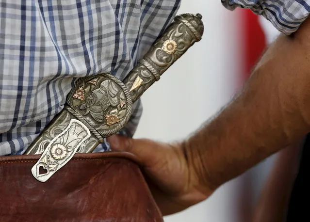 A gaucho wears a knife with the handle and the sheath made of silver and gold during the annual celebration of Criolla Week in Montevideo, March 31, 2015. (Photo by Andres Stapff/Reuters)