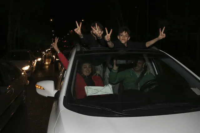 Iranians flash the victory sign from their car while celebrating, on a street in northern Tehran, Iran, Thursday, April 2, 2015, after Iran's nuclear agreement with world powers in Lausanne, Switzerland. (Photo by Vahid Salemi/AP Photo)
