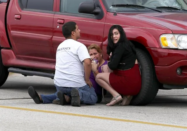 People take cover outside the Fort Lauderdale-Hollywood International airport after a shooting took place near the baggage claim on January 6, 2017 in Fort Lauderdale, Florida. Officials are reporting that five people were killed and 8 wounded in an attack by a single gunman. (Photo by Joe Raedle/Getty Images)