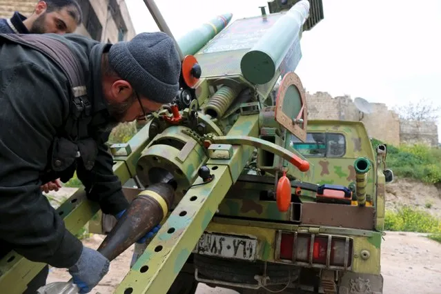Rebel fighters of al-Jabha al-Shamiya (the Shamiya Front) prepare a new, locally made cannon named “al-Qannas” (Sniper), to be launched towards forces loyal to Syria's President Bashar al-Assad stationed in Hanano barracks, in Aleppo April 8, 2015. The cannon is decorated with two mock rockets. (Photo by Abdalrhman Ismail/Reuters)
