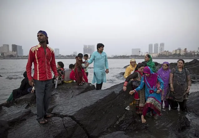 People try to walk on the rocks along the Arabian Sea next to Haji Ali Shrine in Mumbai April 9, 2015. (Photo by Danish Siddiqui/Reuters)