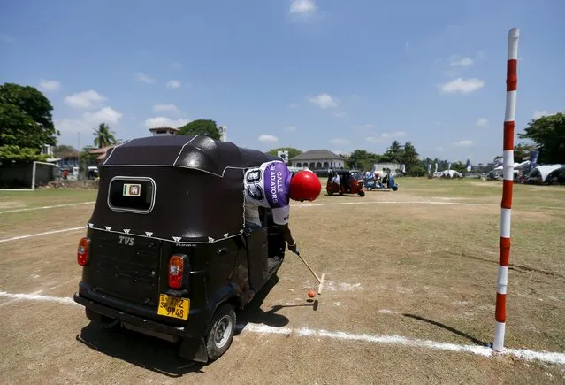 A competitor hits the ball during a “Tuk Tuk” (Three-Wheeled) Polo game in Galle, Sri Lanka on February 21, 2016. (Photo by Dinuka Liyanawatte/Reuters)