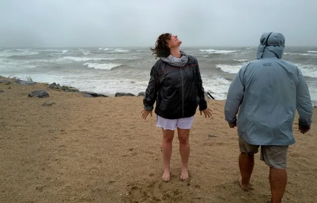 Cliona Becker Stratford, Conn., left, and Andrew Licata, of Jersey City, NJ, experience the wind and waves of Tropical Storm Henri in Montauk, N.Y., Sunday, August 22, 2021. (Photo by Craig Ruttle/AP Photo)