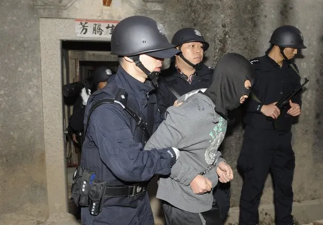 Policemen arrest a suspect during a raid where three tonnes of crystal meth were seized at Boshe village, Lufeng, Guangdong province, December 29, 2013. According to Xinhua News Agency, Lufeng provided one-third of the crystal meth nationwide over the past three years. (Photo by Reuters/Stringer)