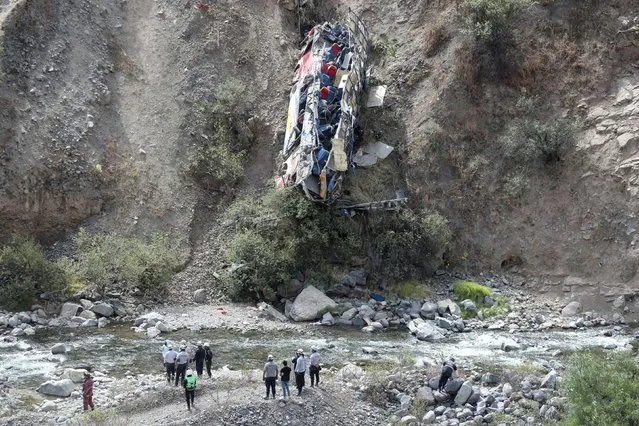 Rescue workers check a bus after it crashed, in Matucana, Peru, August 31, 2021. (Photo by Sebastian Castaneda/Reuters)