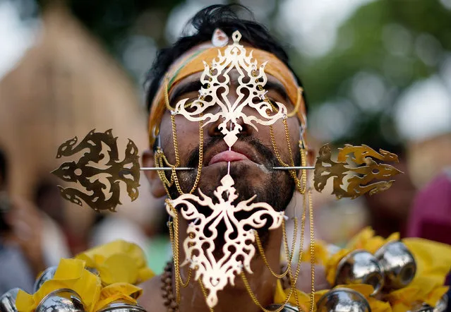 A Hindu devotee's tongue is pierced before making his way towards the Hill Top Murugan temple during the colourful annual Thaipusam festival, one of the world's most extreme displays of religious devotion, in Georgetown on the Malaysian island of Penang on January 17, 2014. The Hindu festival of Thaipusam, which commemorates the day when Goddess Pavarthi gave her son Lord Muruga an invincible lance with which he destroyed evil demons, is celebrated by some two million ethnic Indians in Malaysia. (Photo by Mohd Rasfan/AFP Photo)