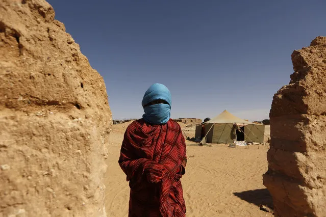 An indigenous Sahrawi woman stands beside a wall of her shelter in a refugee camp of Boudjdour in Tindouf, southern Algeria March 3, 2016. (Photo by Zohra Bensemra/Reuters)
