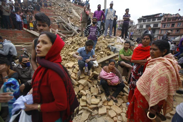 People rest on debris at Durbar Square after an earthquake in Kathmandu, Nepal, Saturday, April 25, 2015. (Photo by Niranjan Shrestha/AP Photo)