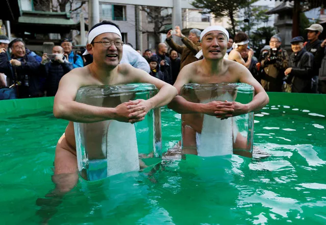 Men wearing loin cloth hold bricks of ice after bathing in ice-cold water in a ceremony to purify souls and wish for good health in the new year at the Teppozu Inari shrine in Tokyo, Japan, January 13, 2019. (Photo by Issei Kato/Reuters)