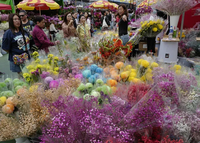 In this Monday, February 4, 2019, photo, people buy flowers at a New Year market in Hong Kong's Victoria Park. Chinese will celebrate the lunar new year on Feb. 5 this year which marks the Year of the Pig in the Chinese zodiac. (Photo by Vincent Yu/AP Photo)